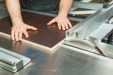 The master prepares the workpiece for cutting on a circular machineの写真素材