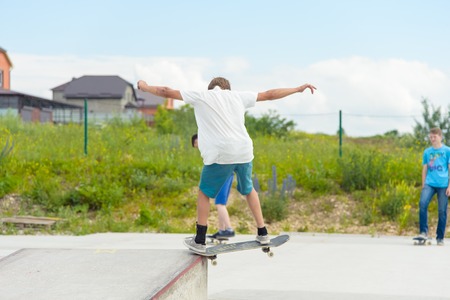 Skateboarding contest in skate park of Pyatigorsk.Young Caucasian skateboarders riding in outdoor concrete skatepark.Skaters compete for prize..Young skater boys ready to roll in on skate rampのeditorial素材