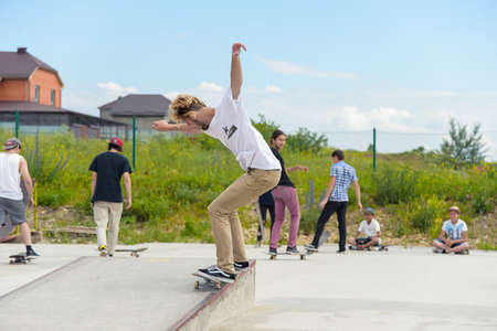 Skateboarding contest in skate park of Pyatigorsk.Young Caucasian skateboarders riding in outdoor concrete skatepark.Skaters compete for prize..Young skater boys ready to roll in on skate rampのeditorial素材