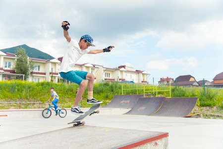 Skateboarding contest in skate park of Pyatigorsk.Young Caucasian skateboarders riding in outdoor concrete skatepark.Skaters compete for prize..Young skater boys ready to roll in on skate rampのeditorial素材