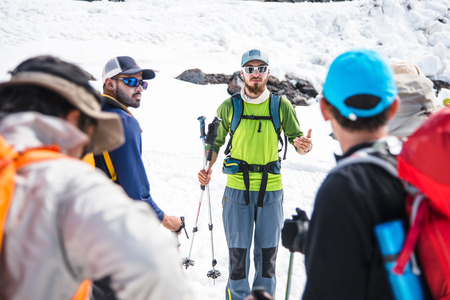 A team of climbers led by a guide discusses the upcoming ascentの写真素材