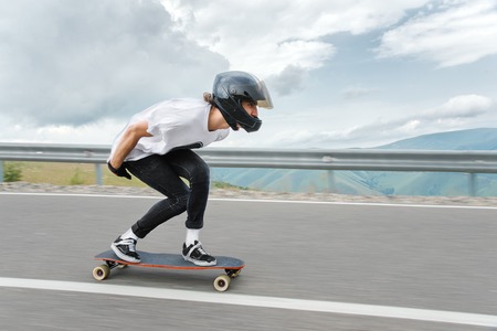 A young guy in a full-face helmet is riding on a country road at high speed in the rainの写真素材
