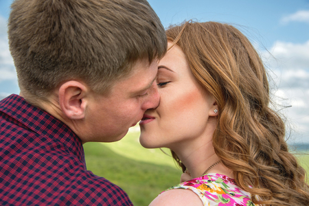 young couple kissing on a background of a landscape close-upの写真素材