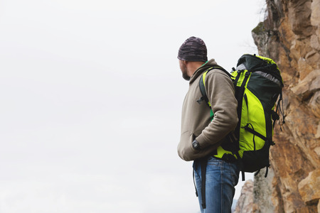 a tourist with a beard in a sweatshirt and with a backpackの写真素材