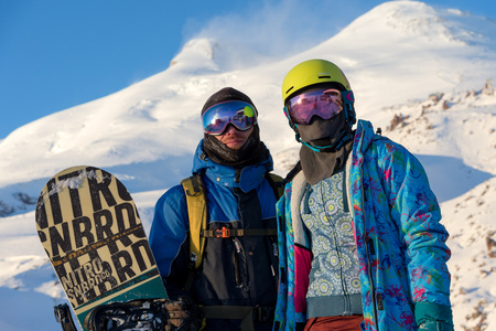 MOUNTAIN ELBRUS, RUSSIA - NOVEMBER 30, 2017: A snowboard couple wearing a sun mask and a scarf is stand on slope. The concept of rest in the mountains in winter.のeditorial素材