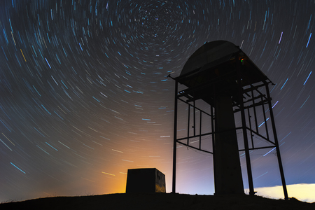 Star tracks in the night sky behind the meteorological autonomous towerの写真素材