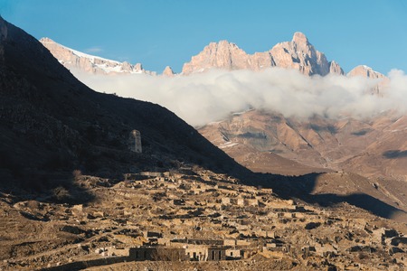 Caucasian mountains. Rock Likoran in Upper Balkaria in the clouds. Winter landscape of bald mountains.の写真素材