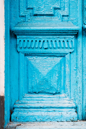 Close-up the Element of blue many times painted cracked double-barreled wooden vintage door of the last century with a post slit.の写真素材