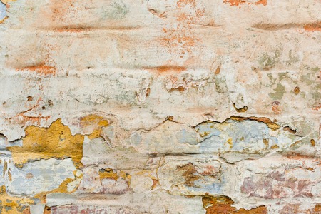 Close-up Textured background of multi-layer flaking paint on the wall. Mixing different colors of paints in the cleaved layers on the surface. Grunge texture with a deep patternの写真素材