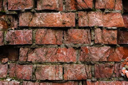 Grunge background Old brick wall weathered and falling apart. The cement interlayers between the...