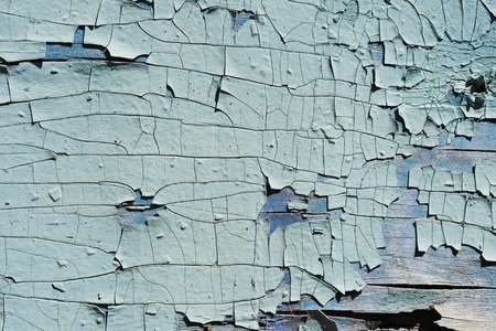 Textured background cracked blue paint on a wooden surfaceの写真素材