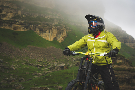 Portrait of a man aged on a mountain bike in the mountains in cloudy weather. Mountain bike conceptの写真素材