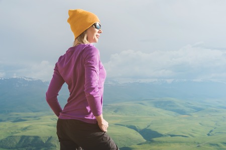 A hipster girl in a straw hat and glasses on the nature landscape