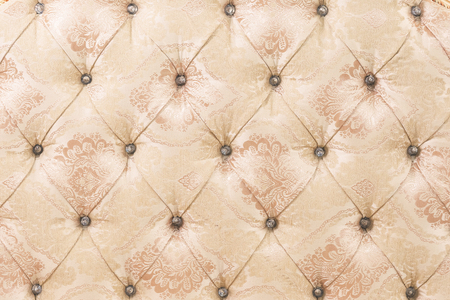 Beige soft tapestry pattern background with symmetrical buttons on the corners of diamonds. Soft and...