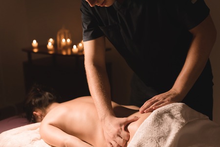 Close-up of male hands. Masseur does massage for the waist of a young girl. Rehabilitation, beauty therapy medicine. healthy conceptの写真素材