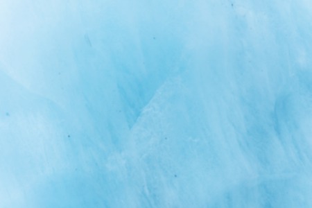 Close-up blurred wall of a centuries-old glacier with a structure of stripes and bubbles. Ice blue light textureの写真素材