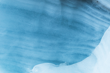 Close-up wall of a centuries-old glacier with a structure of stripes and bubbles. Ice blue light textureの写真素材