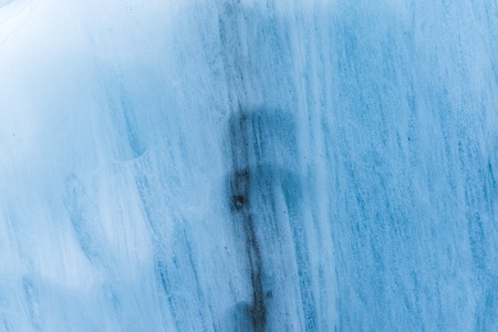 Close-up wall of a centuries-old glacier with a structure of stripes and bubbles. Ice blue light textureの写真素材