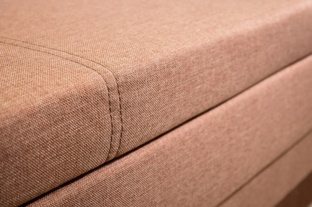 A close-up of a fragment of an expensive beige textile sofa in the roomの写真素材