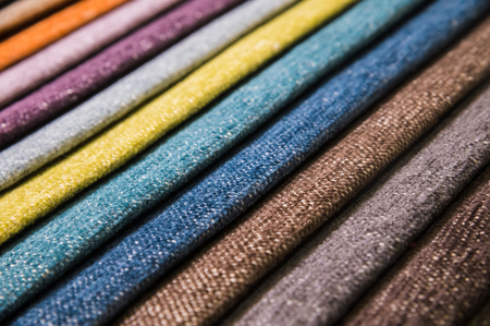 Colorful and bright fabric samples of furniture and clothing upholstery. Close-up of a palette of textile abstract stripes of different colorsの写真素材