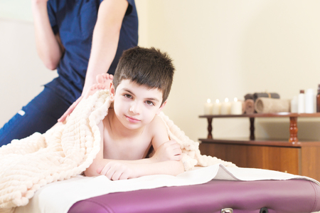 Little boy patient at reception at a professional masseuse. Foot Massage Therapyの写真素材