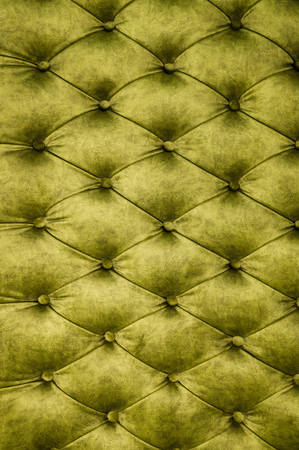 Velor lime surface of sofa close-up. Training equipment-velor mats tightened with buttons. Yellow chesterfield style quilted upholstery backgroundの写真素材