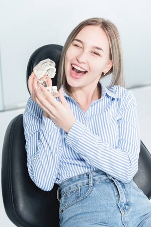 Portrait of a happy attractive girl in a dental chair. Laughing girl at the dentists appointment...