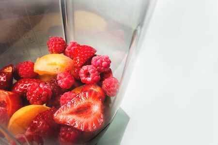Closeup strawberry and apricot lie in a blender poured with fresh yogurt or milk. Healthy and fresh food. The concept of vegetarianismの写真素材