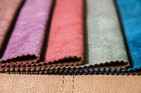 Colorful and bright fabric samples of furniture and clothing upholstery. Close-up of a palette of...