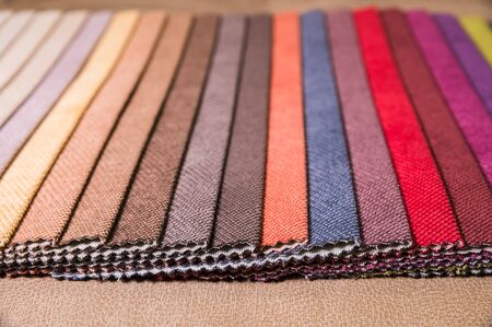 Colorful and bright fabric samples of furniture and clothing upholstery. Close-up of a palette of...