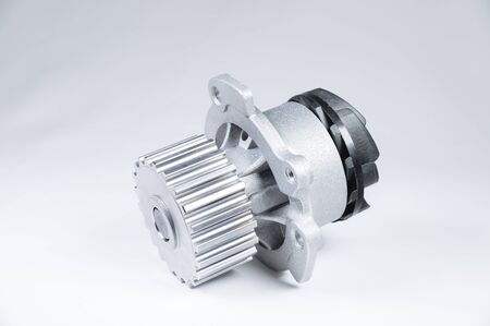 New metal automobile pump for cooling an engine water pump on a gray background with a gradient. The concept of new spare parts for the car engineの写真素材