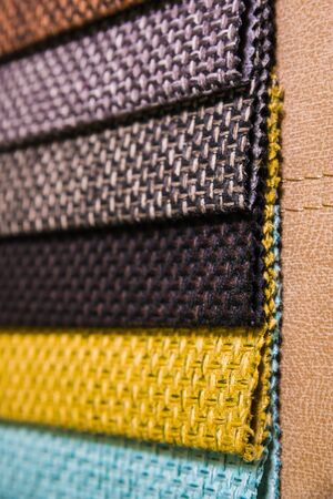 Colorful and bright fabric samples of furniture and clothing upholstery. Close-up of a palette of textile abstract stripes of different colorsの写真素材