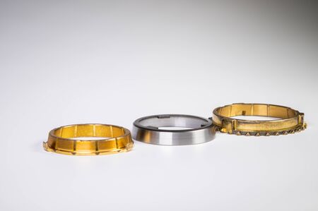 The individual elements of the transmission gear in the gearbox. A new set of synchronizers made of brass on a gray background.の写真素材