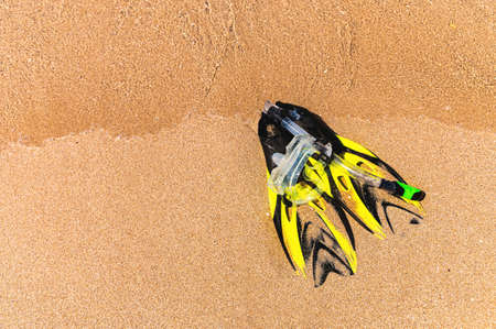 Snorkeling kit. Fins, snorkel and snorkel on the golden beach of the sea or ocean. Vacation and recreation concept on the coastの写真素材