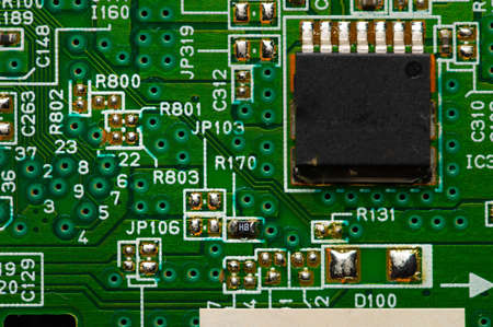 Electronic circuit close-up microchip on a green microcircuit with elements of transistors and...
