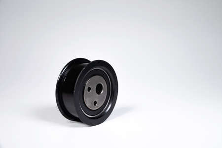 New timing belt tensioner roller close-up macro shot on gray background