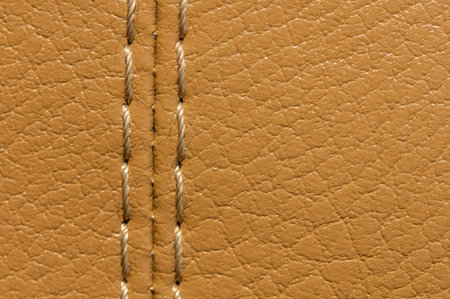 Beige color old leather car upholstery with stitching close-up macro. Textile auto backgroundの写真素材