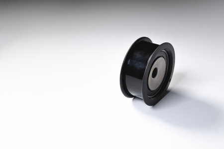 New timing belt tensioner roller close-up macro shot on gray background