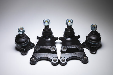 New set of spare parts for the front suspension of the SUV. 4 Ball joints in contrasting light on a...