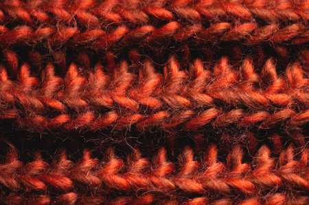 Red-orange knitted background texture. Close-up of knitted stitches. Macro