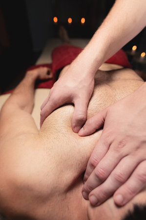 Sports massage. Breast massage. Physiotherapist doing a male breast massage to an athlete to a patient. Close-upの写真素材
