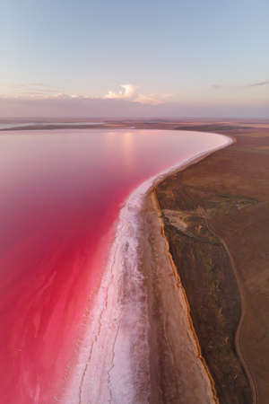 Vertical panoramic salty lake shore with pink salt at dusk after sunset. Aerial viewの写真素材