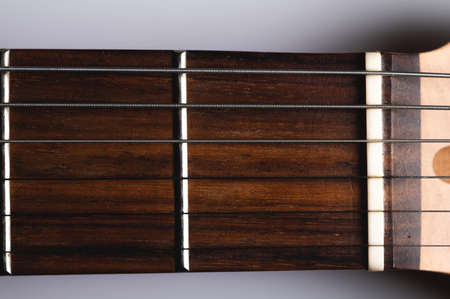 Close-up elements of electric guitar on gray background