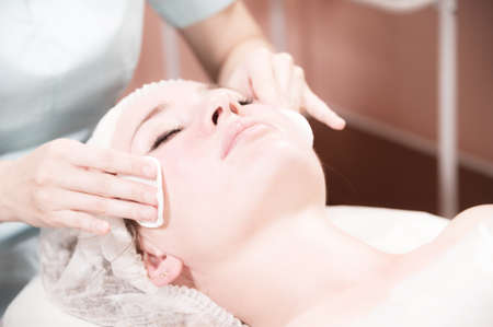 young woman lies in the salon doing a cosmetic procedure with cotton padsの写真素材