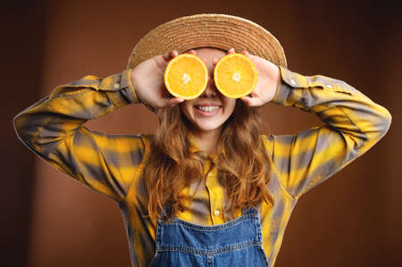Attractive young woman in a straw hat laughs rejoicing in the summer, closing her eyes with halves...