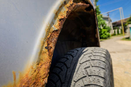 Fragment of a car body with rust. fragment of a rusty wing of a car. The body element is corroded. Concept: corrosion resistance, body repair, rust. Protection.の写真素材