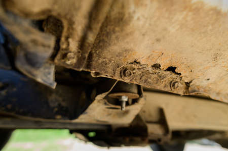 Close-up Body repair and welding work required. Rust on a gray old car. Rust hole on an old worn out painted metal surface.の写真素材