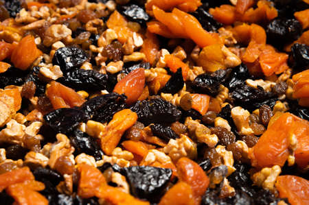 Dried mixture of walnuts and dried fruits, raisins, grapes and prunes close-up. Mix for adding to baked goods or appetizers. Healthy vegan foodの写真素材
