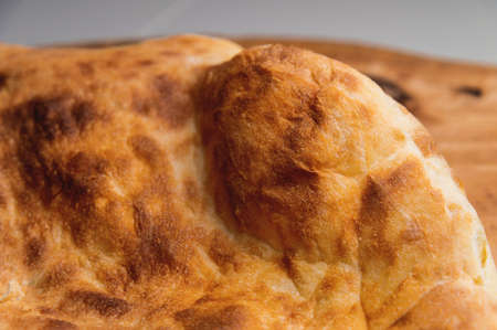 fried khachapuri cooked in the oven lies on a wooden boardの写真素材