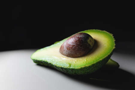 Avocado on old wooden table.Halfs on wooden bowl. Fruits healthy food concept.の写真素材